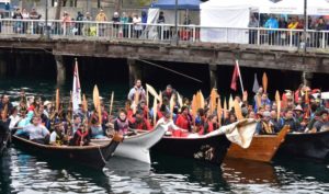 photo of people in canoes in water by pier